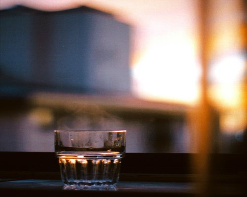 A glass of water near a window reflecting the calm nature of daily habits